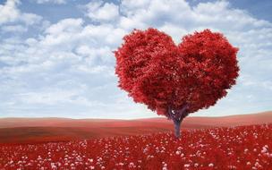 tree in the shape of a red heart on a field against a background of clouds