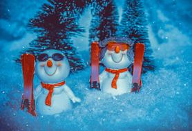 snowmen with skis in the snow as funny figurines