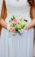 Bride in the beautiful, white wedding dress, with the colorful and beautiful bridal bouquet