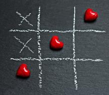 Beautiful, shiny red hearts and white cross in the tic tac toe game