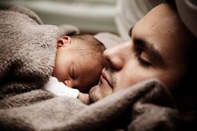 Father, swimming with the baby, in light