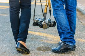 Couple walking on the road with cameras