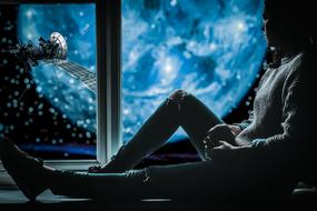 young man at the window looks at the universe