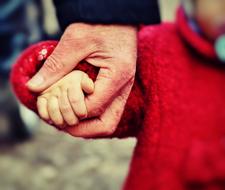 child holds hands of an adult