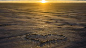 Beautiful heart sign on the sand, in the colorful and beautiful sunset light, in the evening