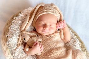 baby in a knitted rabbit costume