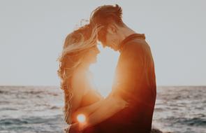 couple in love on the background of the bright evening sun by the sea