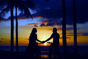 Silhouette of the couple on the landscape with the sunset