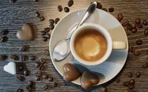 heart shaped cup of coffee and two candies