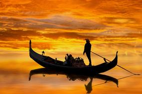 yellow evening sky above the gondola on calm water