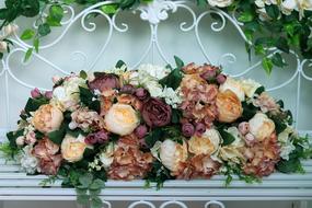 flower arrangement on a white bench