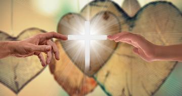 two hands reach for the luminous cross