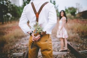 a man with a bouquet of delicate flowers with a blurred background