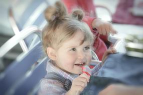 Portrait of a cute, smiling, blonde girl, sitting on a chair