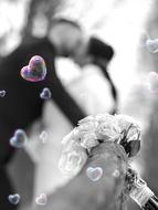 soap bubbles in the shape of hearts on the background of the newlyweds
