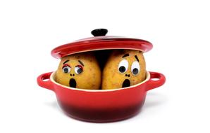 Scared potatoes in the cooking pot on white background clipart