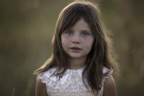 portrait of a cute girl in a white dress on the nature