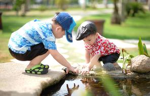 children play on the shore of a pond in Asia