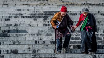 elderly couple on the steps of a temple in Tibet