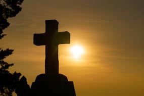 stone cross against the setting sun
