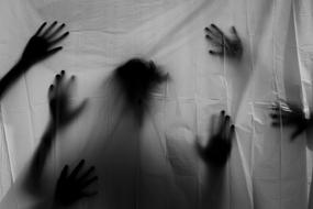 Silhouettes of black hands on a white sheet