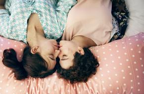 Couple, kissing on the colorful, patterned bed