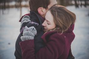 hugs of romantic couple in winter nature