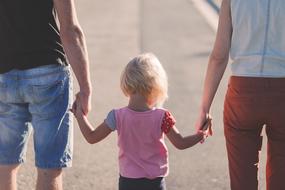 parents with a child go to the beach