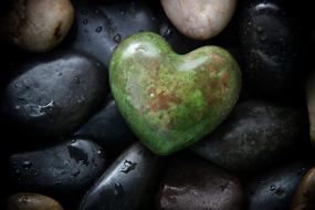 wet pebbles and green stone in the shape of a heart