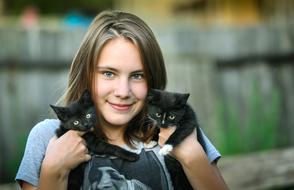 girl with two cute kittens on her hands