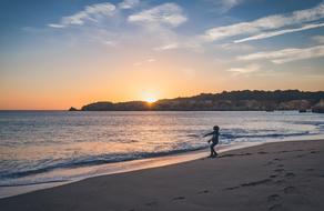 boy on the sandy beach at dusk