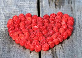 Raspberry Heart shape at grey wooden background