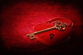 red heart-shaped lock and key on a red background