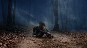 sad young woman in the forest