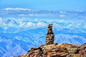 stack of brown stones on rock at gorgeous blue mountain landscape