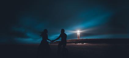 silhouette of Couple holding hands in front of Lighthouse at dusk, digital art