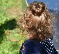 little girl on a sunny day, view from the back