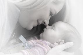 happy Mother kissing sleeping Baby daughter