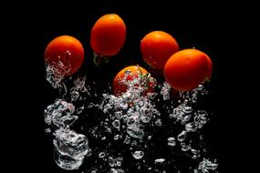 red tomatoes fall into the water