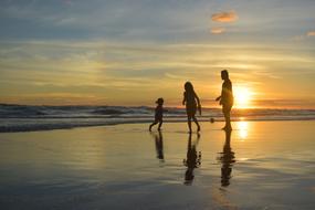 Silhouette of family on beach at Sunset