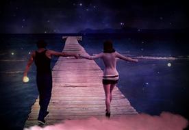 young Couple walking hand in hand on wooden pier at dusk