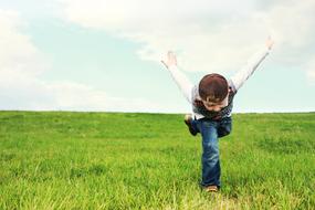 boy depicts a plane on a green meadow