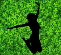 silhouette of a happy girl on a background of green clover leaves