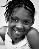 Black and white photo, with the portrait of the cute, smiling girl, in the dress