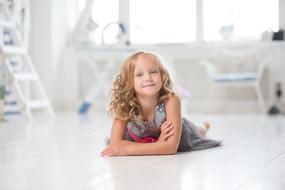 photo of a girl with curly hair is lying on the floor