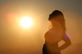 profile of a girl on the background of the bright evening sun