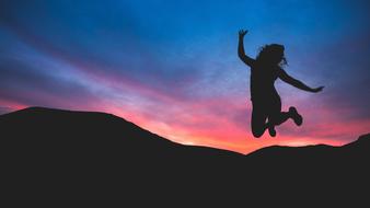 silhouette of jumping woman in dark twilight