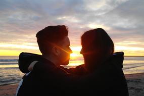 Couple in love on the beautiful beach, at colorful sunrise