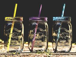 three transparent drinking glasses with tubules