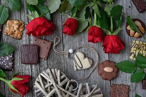 chocolates, a bouquet of roses and a wicker heart on the table